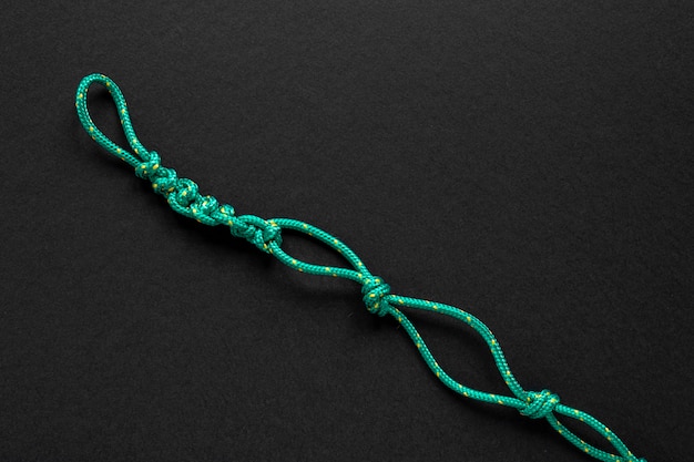 Free photo strong green rope knot on black copy space background