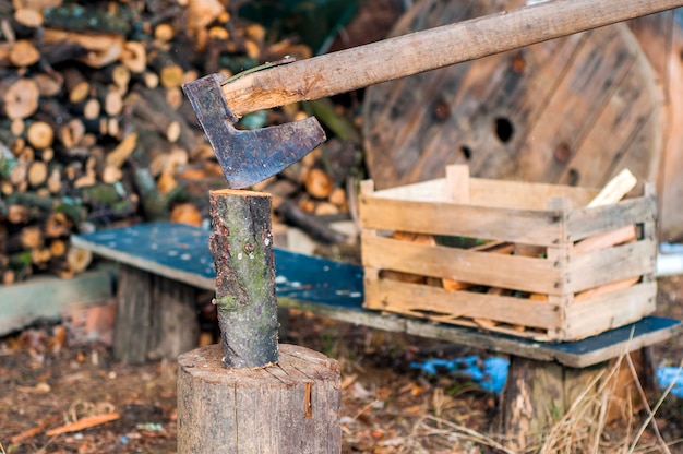 Free Photo strong lumberjack chopping wood, chips fly apart. ax, hatchet, axe. split a log with an ax. birch firewood in the background. wood wallpaper