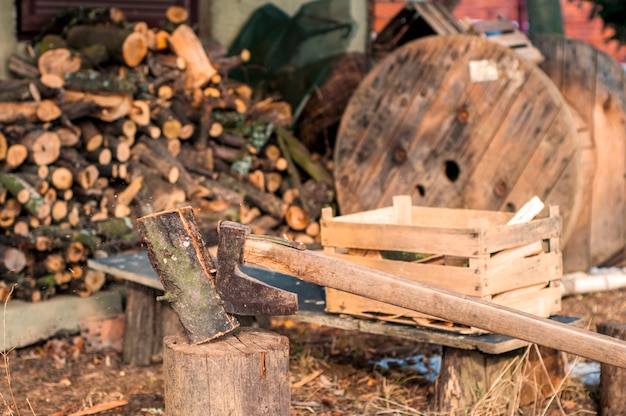 Free photo strong lumberjack chopping wood, chips fly apart. ax, hatchet, axe. split a log with an ax. birch firewood in the background. wood wallpaper