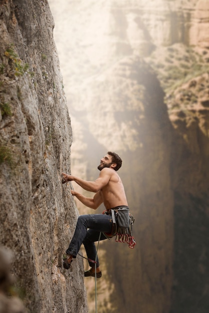 Free photo strong man climbing on a mountain