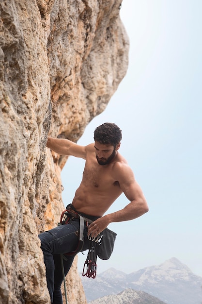 Strong man climbing on a mountain