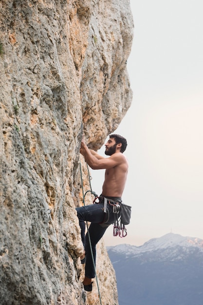 Free photo strong man climbing on a mountain