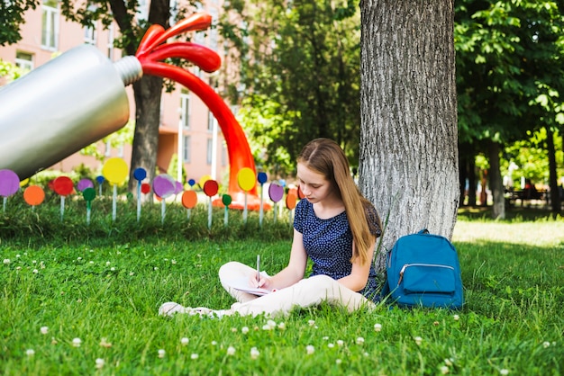 Free photo student doing homework on lawn