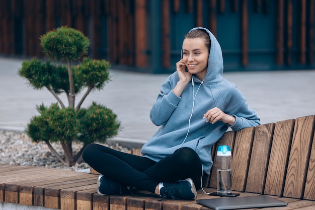 Student in hood listening to music in earphones