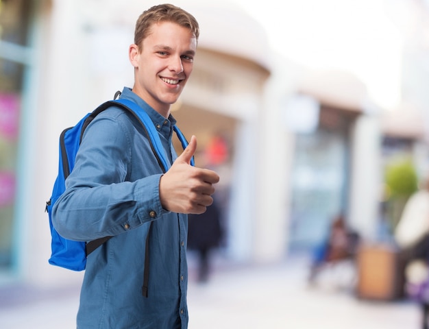 student man with back-pack doing okay sign