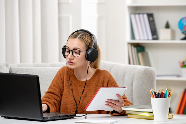 Student online cute girl in glasses and sweater studying on computer typing keyboard