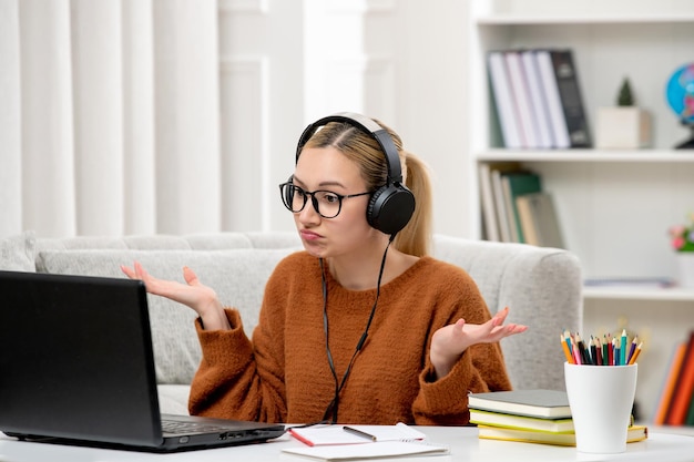 Free photo student online young cute girl in glasses and orange sweater studying on computer waving hands