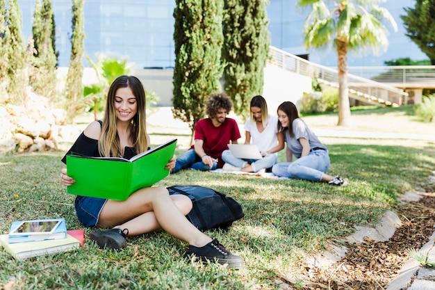 Student reading textbook near university 