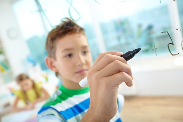 Student solving math problem in classroom