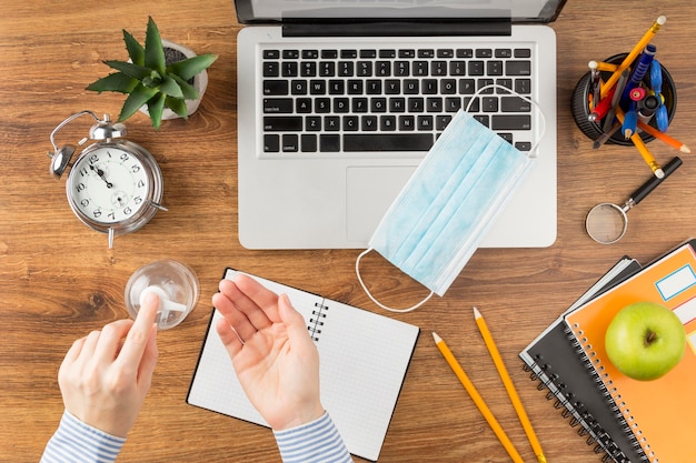 Student using disinfectant above desk