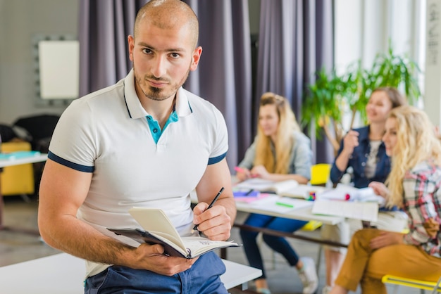 Free Photo student with notebook posing in classroom