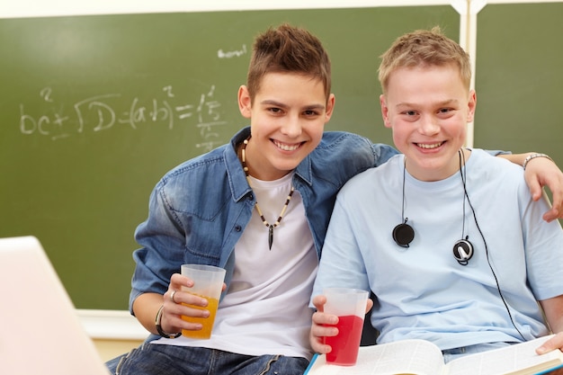 Free Photo students drinking soda in class