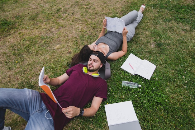 Students lying on grass reading