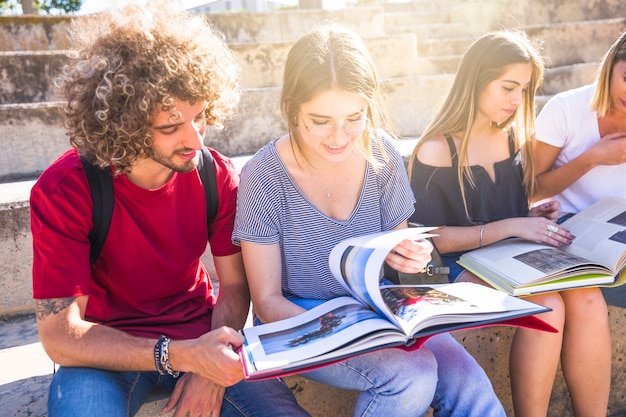 Students reading textbooks on stairs