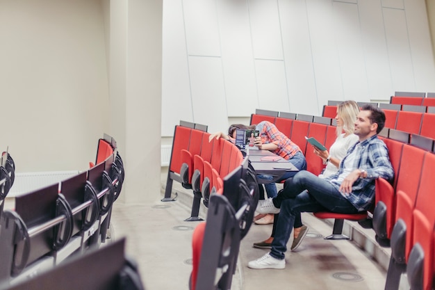 Free photo students sitting in university amphitheatre