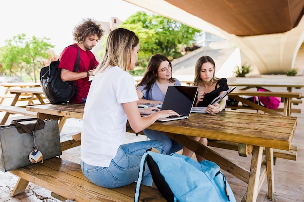 Students studying at table in park