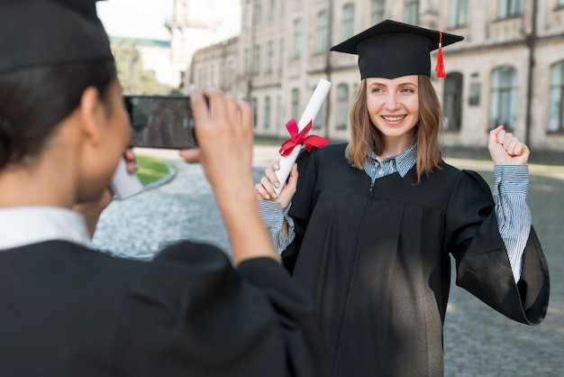 Free Photo students taking photo of each other at graduation