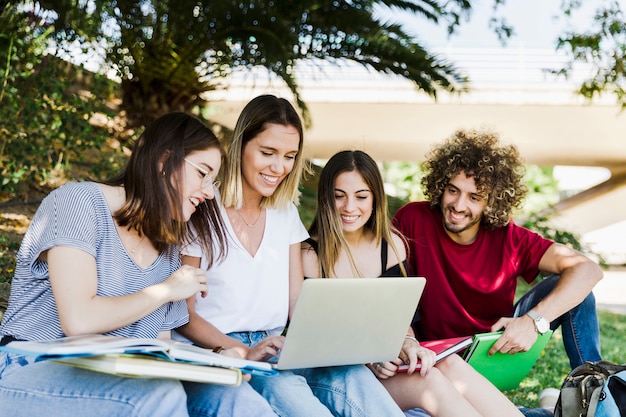 Students using laptop in park