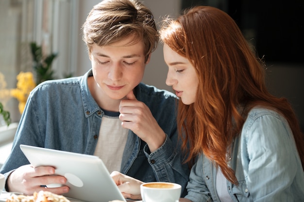 Students using tablet in cafe