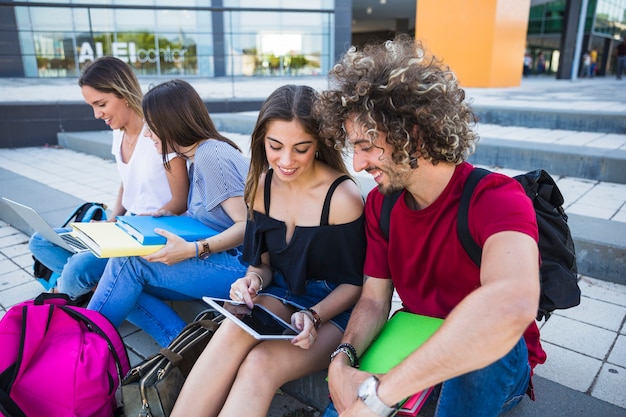 Students using tablet near friends