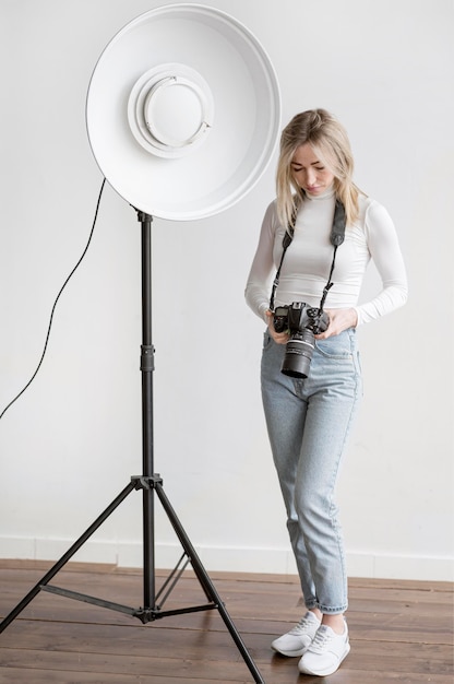 Free Photo studio lamp and woman holding a camera photo