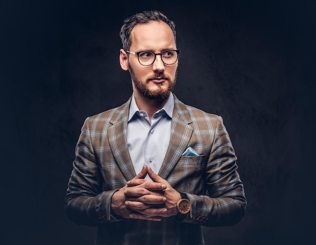 Studio portrait of a bearded hipster in glasses wearing a casual