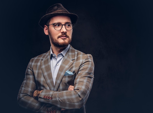 Studio portrait of a bearded hipster in hat and glasses wearing