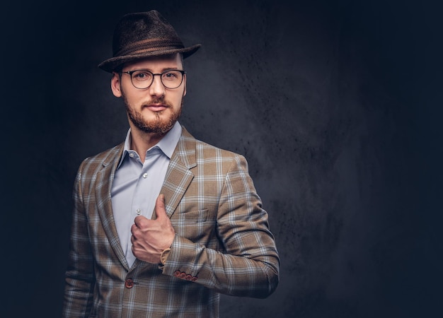 Studio portrait of a bearded hipster in hat and glasses wearing