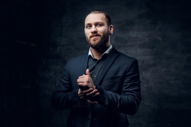 Free photo studio portrait of bearded male with crossed arms, dressed in a blue jacket over grey vignette background.