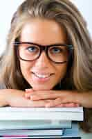 Free photo studio portrait of beautiful young student woman posing with books