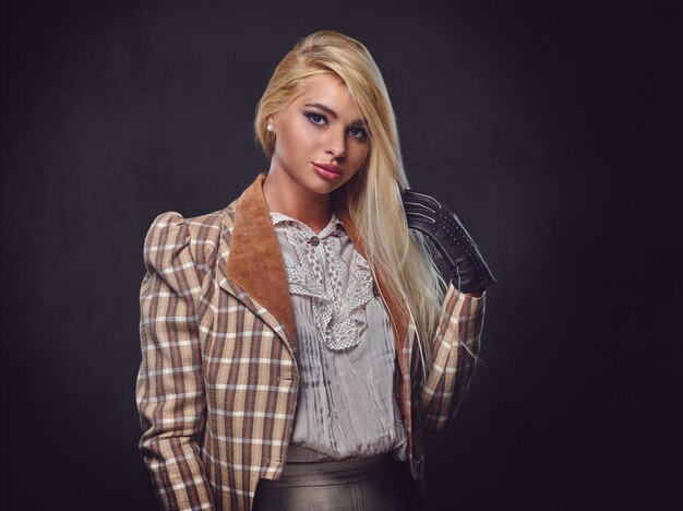 Studio portrait of blond old fashioned female on grey background.