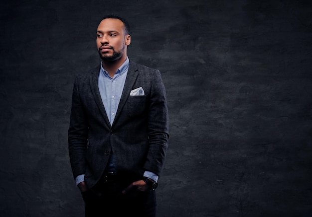 Studio portrait of elegant black American male dressed in a suit over grey vignette background.