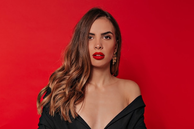 Studio portrait of elegant stylish lady with evening make-up in black dress with bare shoulders