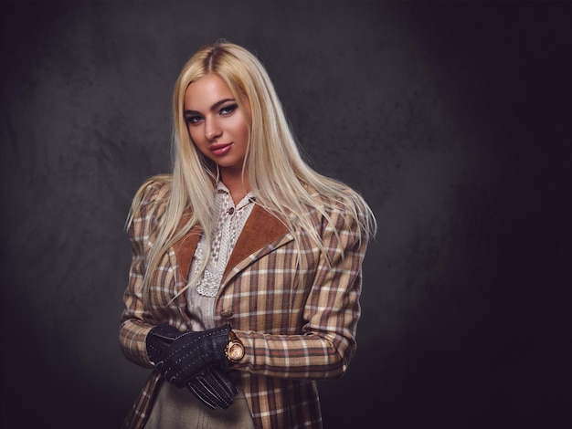 Studio portrait of old fashioned blonde female on grey background.