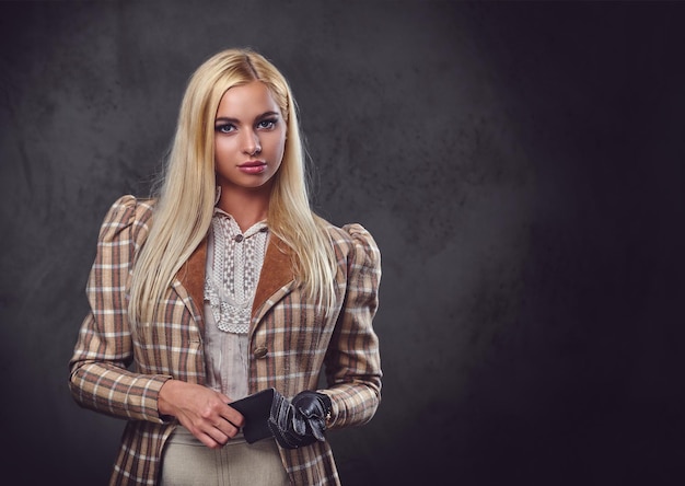 Studio portrait of old fashioned blonde female on grey background.