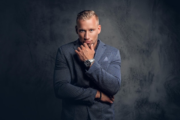 Free photo studio portrait of stylish blond male dressed in a blue suit.