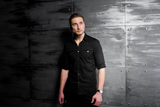 Free photo studio portrait of stylish man wear on black shirt against steel wall