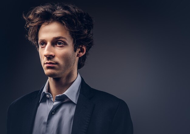 Studio portrait of a stylish sensual male with hairstyle in a casual suit