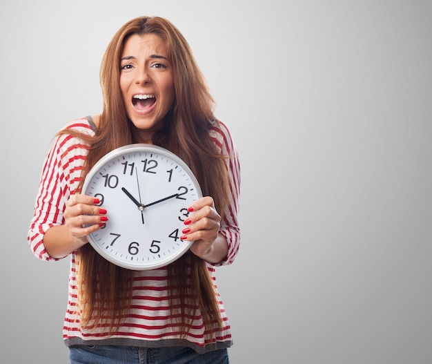 Free photo studio portrait of woman holding big clock