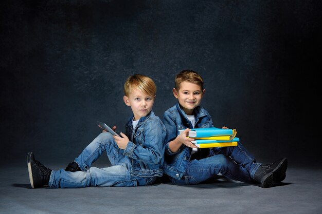 The studio shot of children with books and tablet