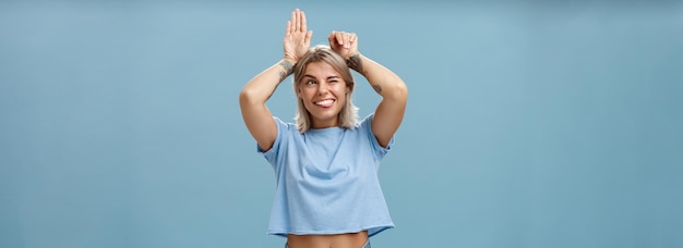 Free photo studio shot of entertained carefree and emotive happy charming woman with tattoos on arms acting lik