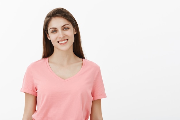 Studio shot of good-looking friendly brunette woman posing in the studio