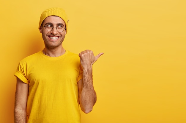 Free photo studio shot of pleased handsome man with toothy smile, white teeth