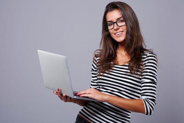 Studio shot of young brunette with laptop