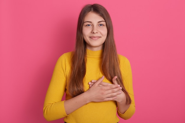 Studio shot of young Caucasian lady posing indoor against pink .