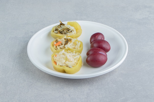 Free Photo stuffed peppers and plums on white plate.  