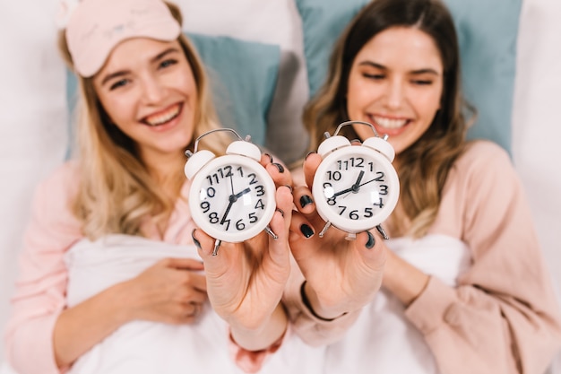 Stunning women in pajamas smiling in bed