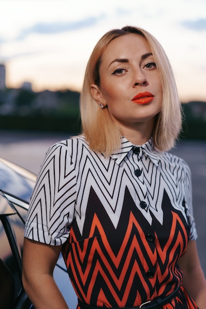 Free Photo stunning young woman close up portrait posing in front of her car outdoors, ownership driver