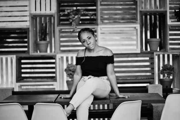 Free Photo stylish african american woman posed and sitting on table