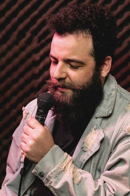 Free photo stylish beard man singing on microphone